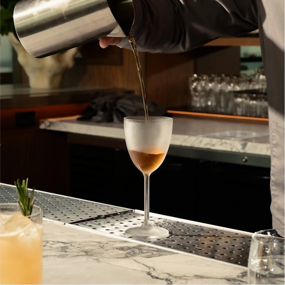 Craft cocktail being poured at Dunya Lounge marble bar