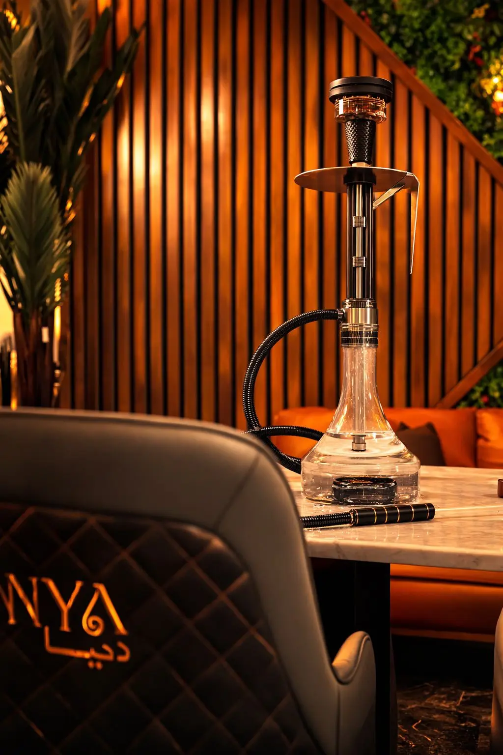 Premium glass hookah at Dunya Lounge with warm ambient lighting and leather seating