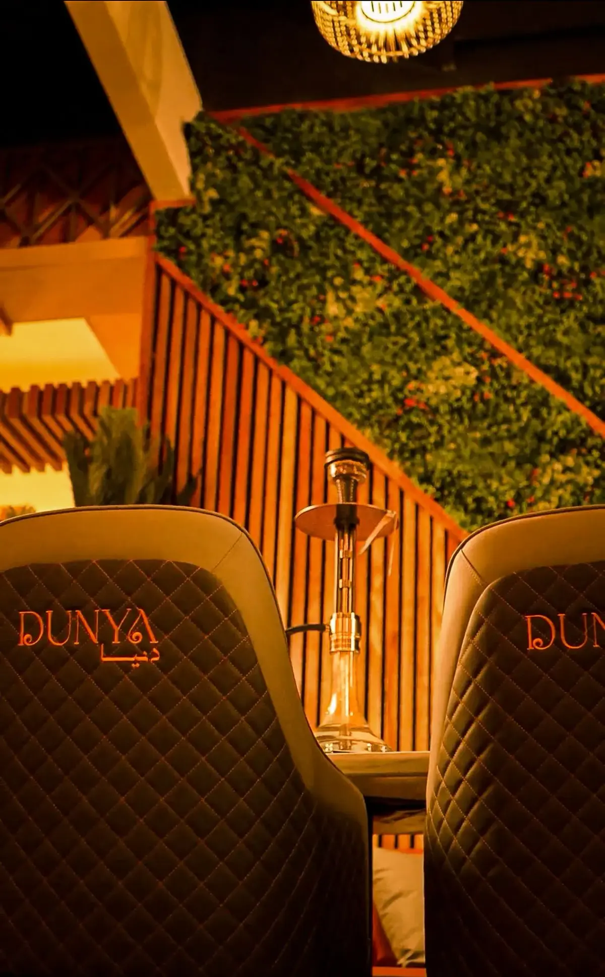 Dunya Lounge hookah between branded leather booths with green living wall