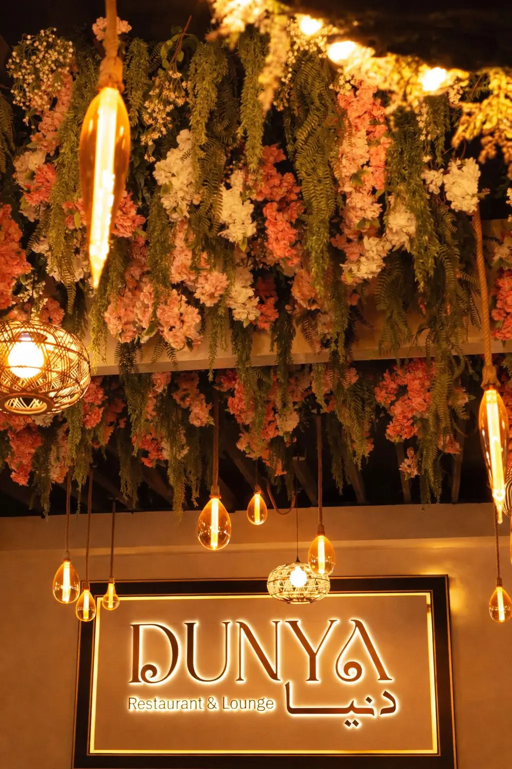 Dunya Lounge illuminated sign with hanging floral ceiling installation