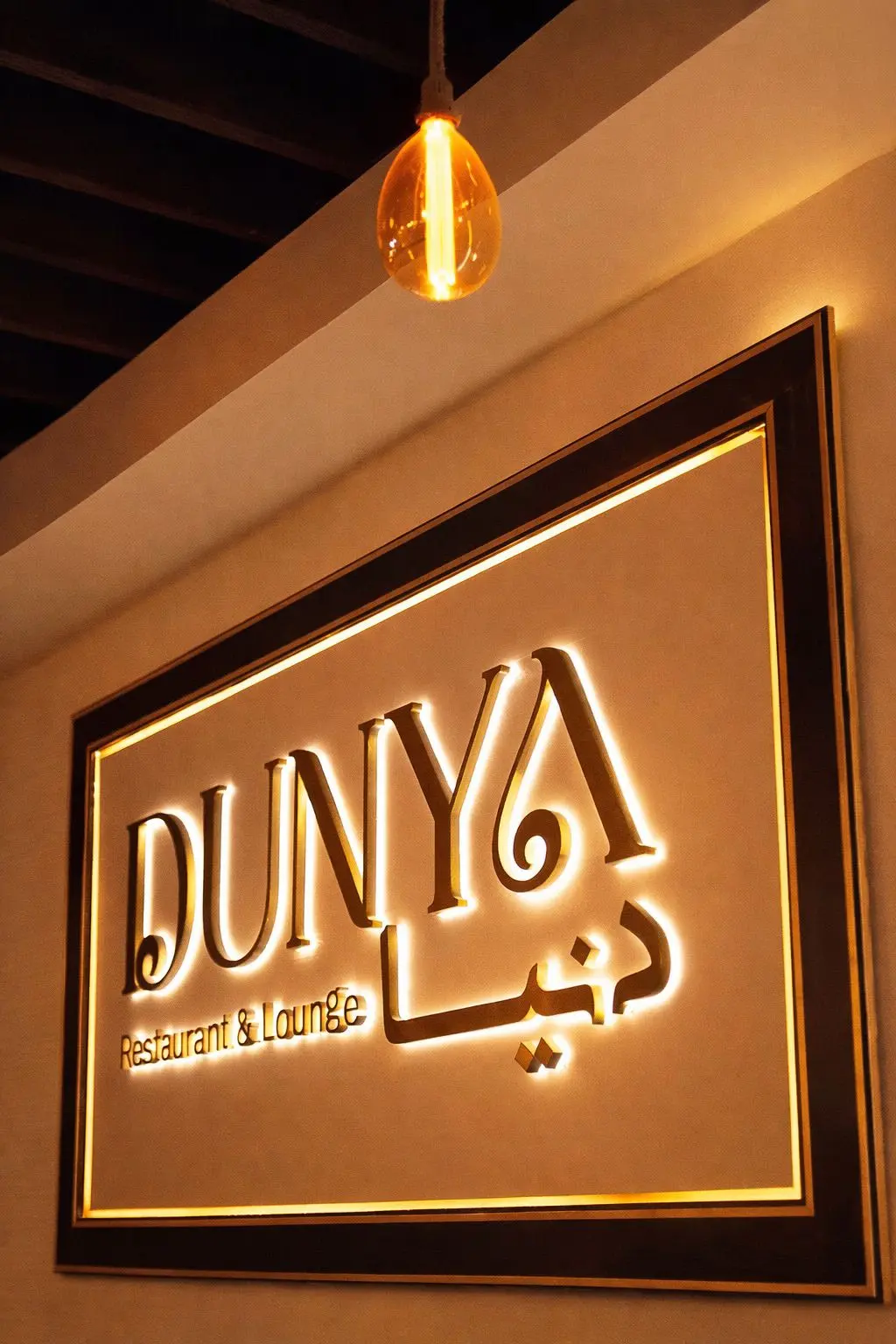 Dunya Lounge gold-framed illuminated sign with ambient lighting